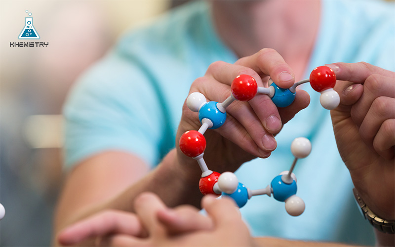 A student using an atomic molecule model educational toy to study science.