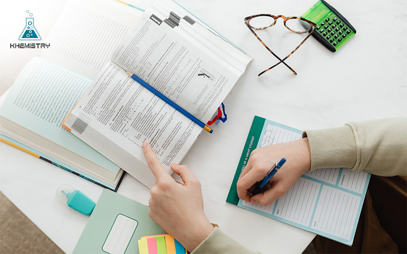 Person studying books and writing down notes